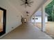 Spacious covered back patio featuring white columns, ceiling fans, and concrete flooring at 4024 Landsford Rd, Marshville, NC 28103