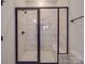 Modern shower with white marbled tile, black frame, glass door, shower head, and built-in bench at 4024 Landsford Rd, Marshville, NC 28103