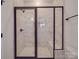 Modern shower with white marbled tile, black frame, glass door, shower head, and built-in bench at 4024 Landsford Rd, Marshville, NC 28103