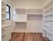 Bright walk-in closet with custom white shelving and drawers, wood floor, and natural light at 4024 Landsford Rd, Marshville, NC 28103