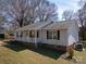 Inviting single-story home with a covered front porch, light gray siding, and neatly trimmed landscaping at 403 Easy St, Concord, NC 28027