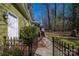 View of the backyard featuring a fenced-in area, mature landscaping, and a walkway leading to the deck at 4301 Old Forge Dr, Gastonia, NC 28056
