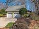 Spacious two-car garage with lush landscaping, a walkway, and a glimpse of the home's backyard at 4301 Old Forge Dr, Gastonia, NC 28056