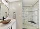Modern bathroom featuring vessel sink on a white vanity, a frameless glass shower with black hardware and marble-like tiling at 4522 Pendock Ct, Charlotte, NC 28226