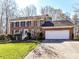 Traditional brick home with an attached two-car garage, green lawn and an American flag at 4522 Pendock Ct, Charlotte, NC 28226