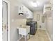 A tidy laundry room with washer and dryer, utility sink, shelving, and ample counter space at 4522 Pendock Ct, Charlotte, NC 28226