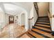 Inviting foyer with stone floors, arched doorways, and a staircase with black risers and wood treads at 4531 Montibello Dr, Charlotte, NC 28226