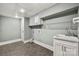 Well-lit laundry room with gray tile floor and modern sink and faucet at 4531 Montibello Dr, Charlotte, NC 28226