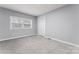 A well-lit bedroom featuring neutral walls, plush carpeting, and a window offering natural light at 5329 Southampton Rd, Charlotte, NC 28217