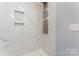 Modern shower with a marble-like tile surround and a multi-setting shower head panel at 5329 Southampton Rd, Charlotte, NC 28217