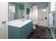 Bathroom with tub/shower combination, blue vanity with white sink, white toilet, and gray tile floor at 547 Lake Shore Dr, Norwood, NC 28128