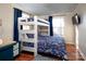 Bedroom with bunk beds, windows with dark curtains, light walls and wood-look floors at 547 Lake Shore Dr, Norwood, NC 28128