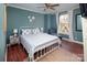 Charming bedroom features stylish white frame bed, blue walls, ceiling fan and window with lots of natural light at 547 Lake Shore Dr, Norwood, NC 28128