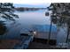 Aerial perspective of a boat dock with a slide, alongside a well-kept boathouse near the water at 547 Lake Shore Dr, Norwood, NC 28128
