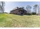 Back exterior view of brick home showing the screened in porch, finished basement, and lake in the distance at 5628 Creole Rd, Clover, SC 29710