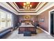 Comfortable main bedroom featuring an elegant tray ceiling with chandelier and large window to view the lake at 5628 Creole Rd, Clover, SC 29710