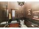 Stylish powder room with dark wallpaper, framed mirror, unique lighting fixture and a toilet at 5628 Creole Rd, Clover, SC 29710