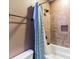 Close-up of tiled shower with a rainfall showerhead, built-in niche and a blue shower curtain at 5628 Creole Rd, Clover, SC 29710