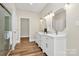 Bathroom boasts double vanity with white cabinetry, wood-look floors, and walk-in shower at 609 Rosemore Pl, Rock Hill, SC 29732