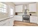 Kitchen showcasing white cabinets, a stainless steel oven, and a tile backsplash at 609 Rosemore Pl, Rock Hill, SC 29732