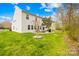 Spacious backyard with a patio, grill, fire pit, and ample green space surrounded by trees and greenery at 6126 Castlecove Rd, Charlotte, NC 28278