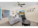 Cozy bonus room features a comfortable gray couch, a TV, and natural light from the window at 6126 Castlecove Rd, Charlotte, NC 28278