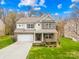 Charming two-story home featuring a combination of brick and siding with a well-manicured lawn and attached garage at 6126 Castlecove Rd, Charlotte, NC 28278