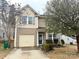 Two-story home featuring a single-car garage, manicured landscaping, and charming architectural details at 719 Mountain Quail Dr # 34, Charlotte, NC 28216