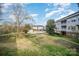 Grassy backyard with view of pool, community building, and condo building at 8629 Coralbell Ln, Charlotte, NC 28213