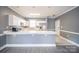 Modern kitchen boasts white cabinets, stainless steel appliances, and convenient breakfast bar at 8629 Coralbell Ln, Charlotte, NC 28213