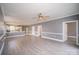 Large living area with hardwood floors, ceiling fan, and open layout leading to kitchen and dining at 8629 Coralbell Ln, Charlotte, NC 28213