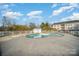 Community pool surrounded by concrete deck, trees, and building in the background at 8629 Coralbell Ln, Charlotte, NC 28213