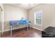 A bright bedroom with hardwood floors, a twin bed, and a window at 8923 Meadow Vista Rd, Charlotte, NC 28213