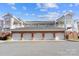 Residential condo building featuring well-maintained garage parking and brick facade under blue skies at 8923 Meadow Vista Rd, Charlotte, NC 28213