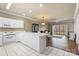 Open-concept kitchen featuring white cabinets, tile flooring, modern appliances, and seamless access to the living room at 8923 Meadow Vista Rd, Charlotte, NC 28213