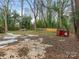 Large backyard with a few trees and temporary debris at 911 E Woodlawn Rd, Charlotte, NC 28209