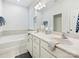 Bright bathroom featuring a double vanity, soaking tub, and neutral tile flooring at 1008 Hills Oak Ln, Charlotte, NC 28269