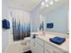Bathroom featuring a vanity with a sleek countertop, a mirror, and a shower with a decorative curtain at 1008 Hills Oak Ln, Charlotte, NC 28269