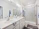 Bathroom with a double vanity, framed mirrors, glass shower doors, and white cabinets at 1008 Hills Oak Ln, Charlotte, NC 28269