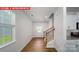 View from kitchen nook into light, bright entryway with wood flooring and staircase at 11217 Cardinal Creek Ave, Charlotte, NC 28215