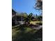 A screened-in porch overlooks a backyard featuring tropical foliage, manicured walkways, and a separate storage shed at 121 Alexis Forest Dr, Stanley, NC 28164
