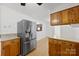 Kitchen area boasting stainless refrigerator, wood cabinets and hardwood floors at 121 Alexis Forest Dr, Stanley, NC 28164