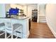 A modern basement bar with barstool seating, floating shelves, and stairs at 12508 Asbury Chapel Rd, Huntersville, NC 28078