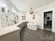 Bright bathroom featuring soaking tub, dual vanity, subway tile, and open closet at 12508 Asbury Chapel Rd, Huntersville, NC 28078