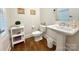 Stylish powder room with wood floors, pedestal sink, and modern fixtures at 12508 Asbury Chapel Rd, Huntersville, NC 28078