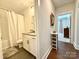 A simple bathroom with a shower-tub combo with a white shower curtain and view to the bedroom at 12508 Asbury Chapel Rd, Huntersville, NC 28078