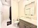 A bright bathroom featuring a gray vanity with quartz countertop, a toilet, and a tiled shower-tub combo at 12508 Asbury Chapel Rd, Huntersville, NC 28078