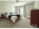 Comfortable bedroom with a wooden bed frame, plush carpet, and neutral tones at 12508 Asbury Chapel Rd, Huntersville, NC 28078