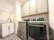 Functional laundry room featuring modern washer, dryer, stylish tile and ample storage at 12508 Asbury Chapel Rd, Huntersville, NC 28078