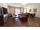 An open concept living room featuring a leather couch, hardwood floors, and a dining area at 12508 Asbury Chapel Rd, Huntersville, NC 28078